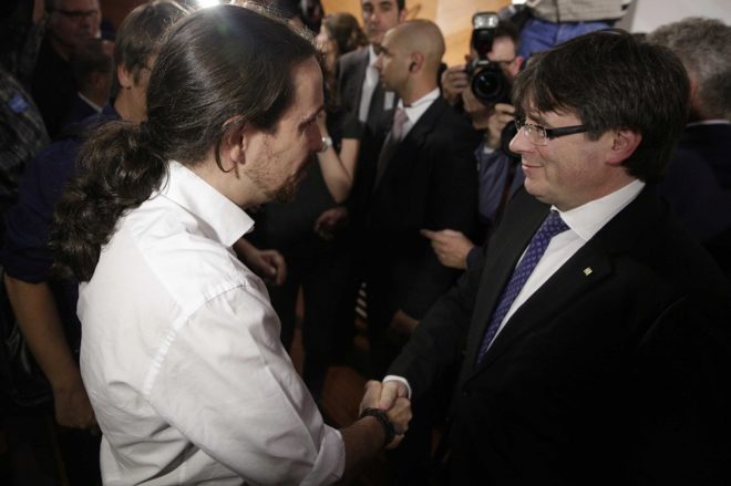 Pablo Iglesias y Carles Puigdemont se saludan en el acto en Madrid en...