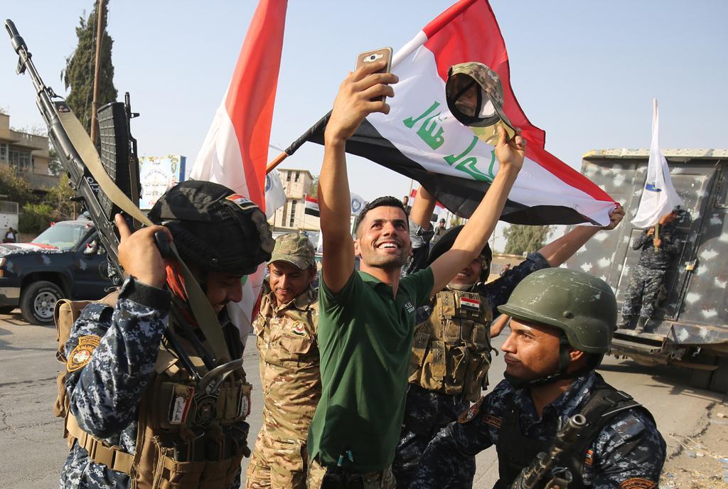 Un iraqu se saca una foto con las fuerzas de seguridad para celebrar la cada de Mosul, ayer.