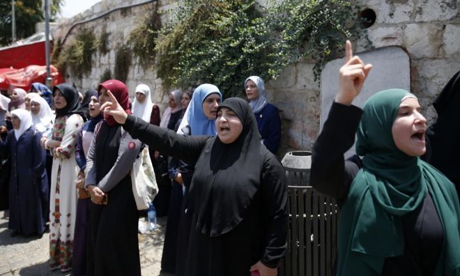 Mujeres palestinas corean eslganoes en la entrada de Al Aqsa, en protesta por las nuevas medidas de seguridad.