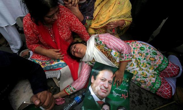 Una seguidora del 'premier' pakistan sufre un desmayo tras conocer la decisin del Tribunal Supremo, en Lahora, Pakistn