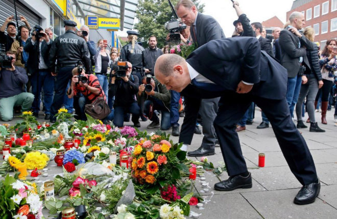 El alcalde de Hamburgo, Olaf Scholz, deja unas flores en el lugar del ataque.