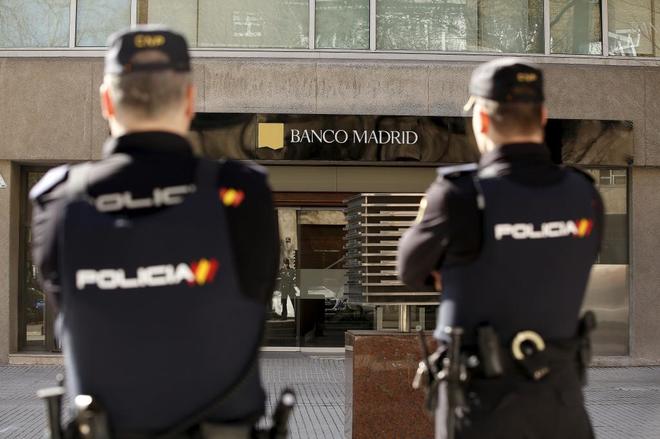 Agentes de la Polica vigilan una sucursal de Banco Madrid, tras la...