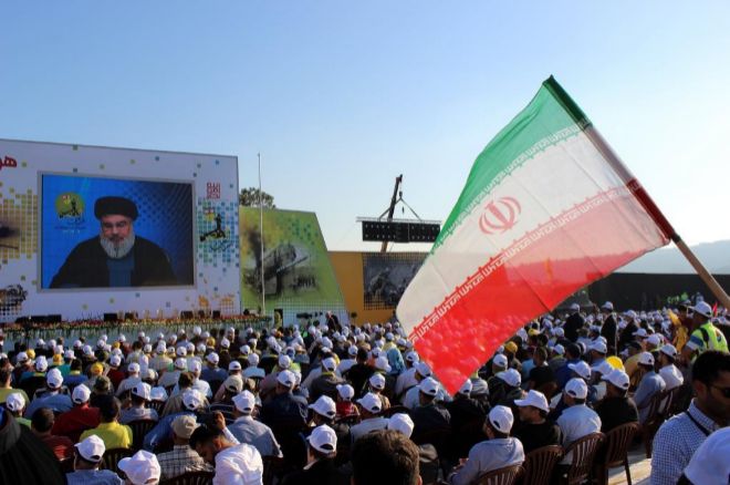 Una bandera iran ondea en un mitin de Hizbul mientras su secretario general se dirige a sus seguidores.