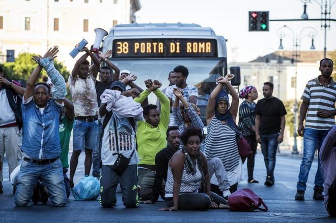 Un centenar de inmigrantes protestan en la plaza de la Independencia en Roma, tras haber sido desalojados.