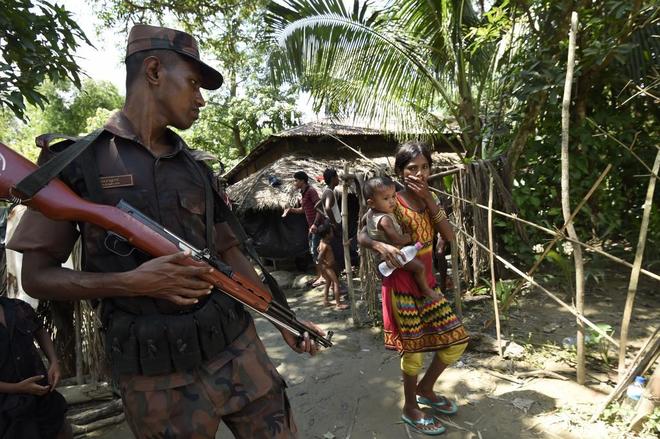 Un guarda de frontera de Bangladesh  vigilan a los refugiados rohingyas, en el campo de Jalpatoli, en Ukhia.