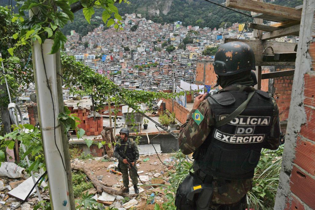 Una pareja de policas militares patrulla la favela. Tres personas...