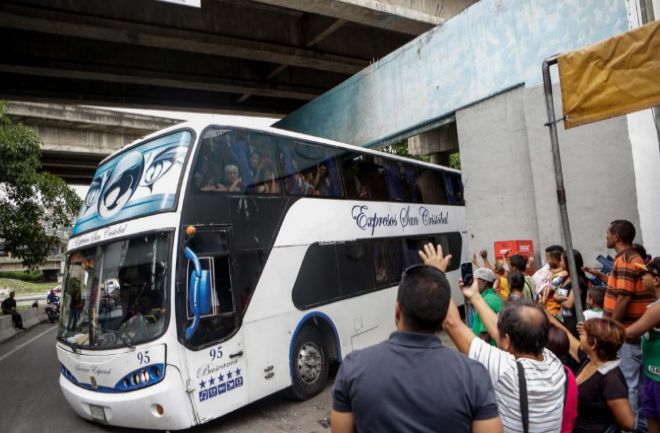 Un grupo de personas a bordo uno de los autobuses en Caracas con destino a diferentes países sudamericanos.