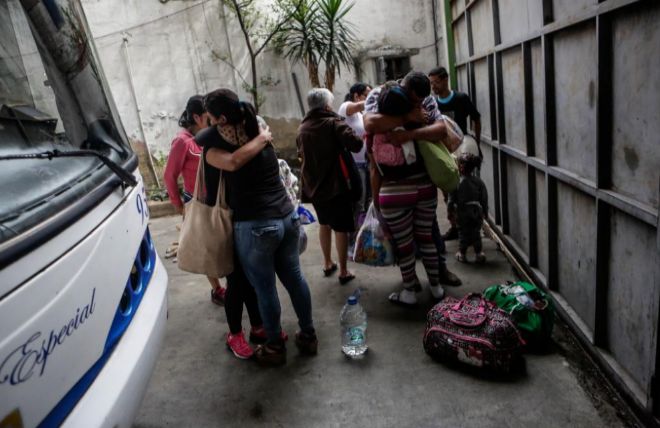 Familias se despiden junto al autobús que les permitirá huir de Venezuela.