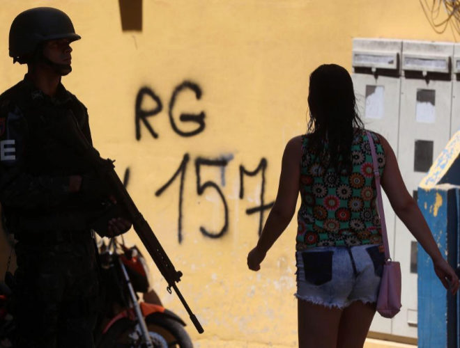 BRA01. RÍO DE JANEIRO (BRASIL), 10/10/2017.- Soldados de las fuerzas armadas brasileñas participan en un operativo en la favela Rocinha, junto a una pared donde se lee "RG 157", iniciales de Rogério 157, líder del narcotráfico en la comunidad hoy, martes 10 de octubre de 2017, en la ciudad de Río de Janeiro, (Brasil). Más de un millar de efectivos de las Fuerzas Armadas y la Policía brasileña realizaron una operación en la favela de Rocinha, la mayor de Río de Janeiro, apenas un día después del hallazgo de dos cadáveres, supuestamente de narcotraficantes. EFE/Marcelo Sayão