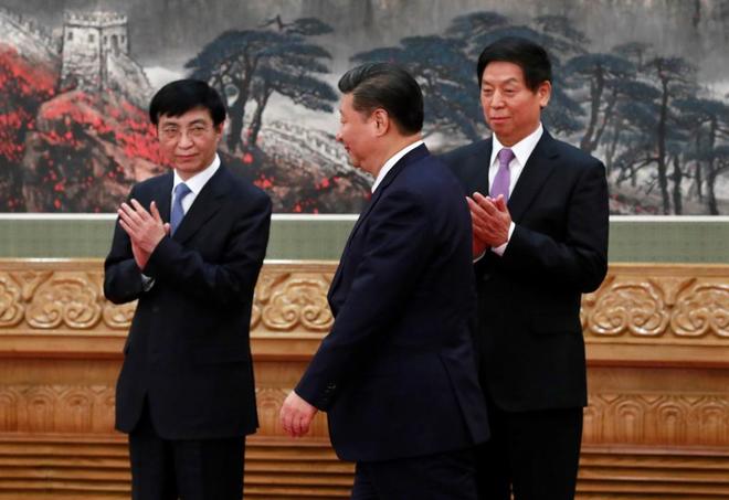 El principal ideólogo del PCCh y padre del "neoautoritarismo" chino, Wang Hunin (a la izquierda) aplaude al paso del  Xi Jinping