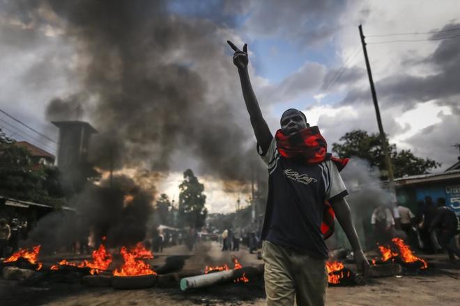 Un seguidor de Odinga, da indicaciones ante una barricada formada para evitar el reparto de material electoral en Nairobi, Kenia.