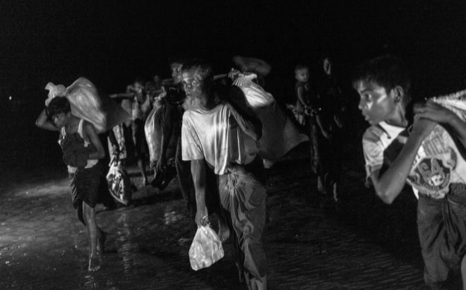 Varios hombres y nios trasladan sus escasas pertenencias al cruzar el ro Naf, hacia Bangladesh.