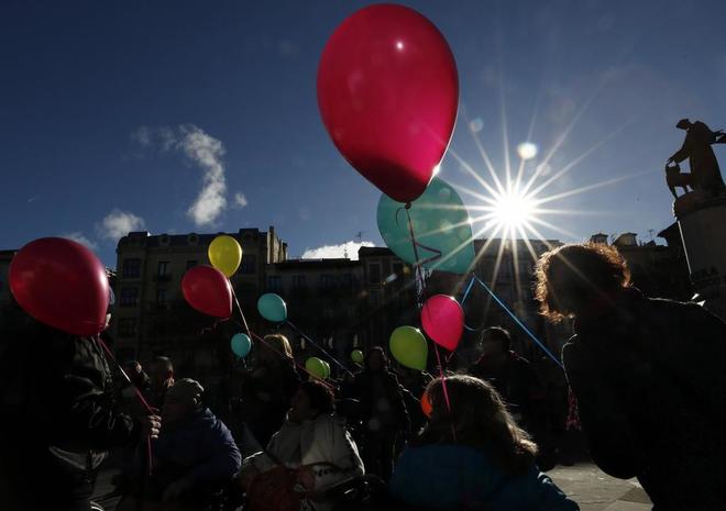 Un grupo de personas recorre con globos las calles de Pamplona en la...