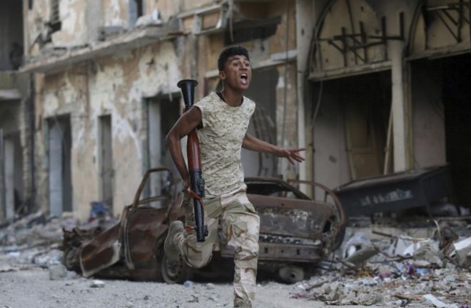 Un miembro del Ejército Nacional Libio, liderado por Jalifa Hafter, corre durante un enfrentamiento con una milicia rival en Bengasi.