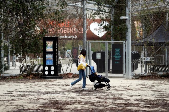 Una mujer camina junto a una puerta cerrada del zoo de Vincennes, hoy en Pars, Francia.