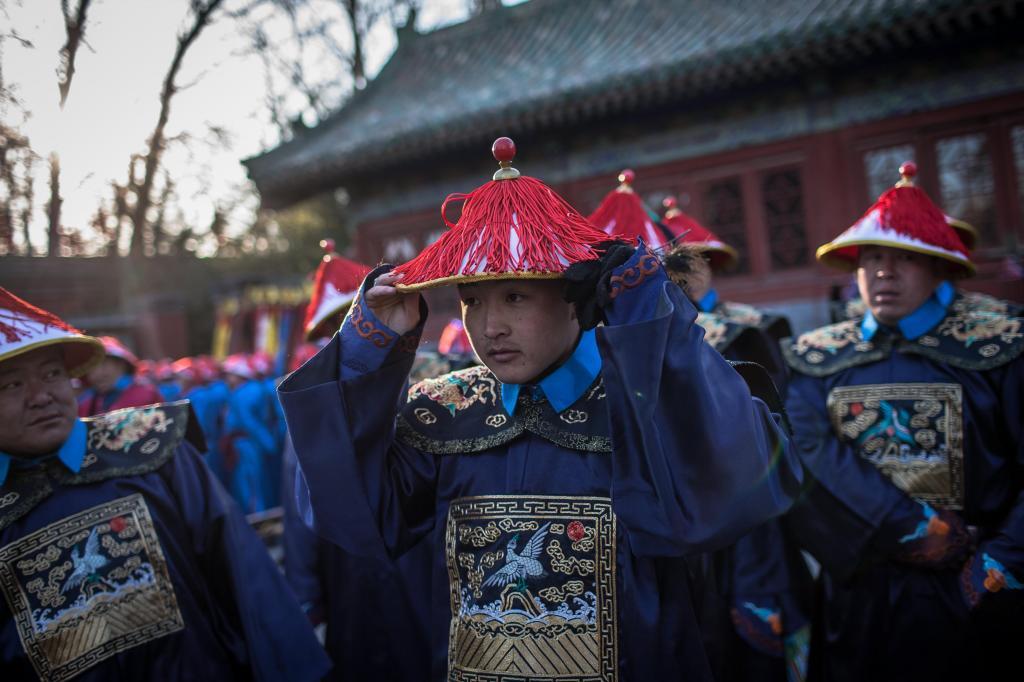 Un grupo de artistas chinos vestidos con trajes tradicionales en...