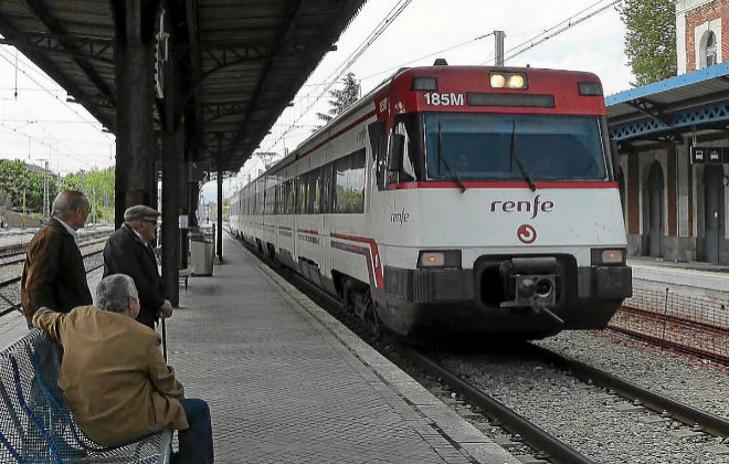 Varios pasajeros esperan al tren en una estacin de Renfe.