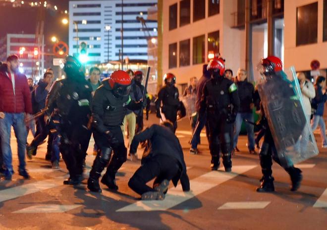 Varios ertzaintzas controlan a un ultra durante los disturbios del...