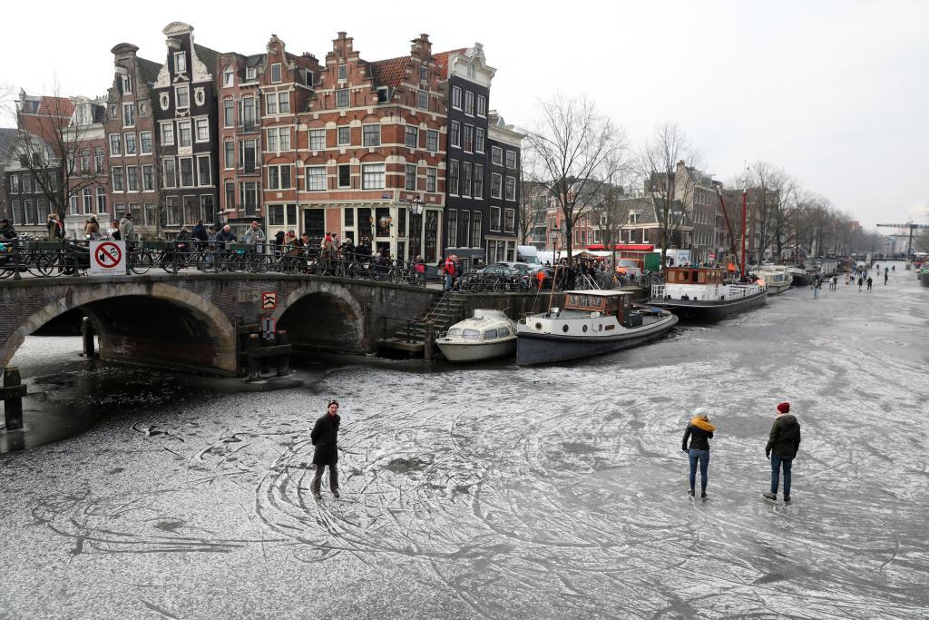 Patinadores sobre los canales helados de Prinsengracht y...