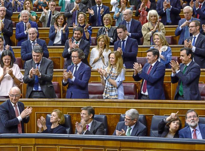 Los diputados del PP aplauden ayer a Montoro, mientras Rajoy y...