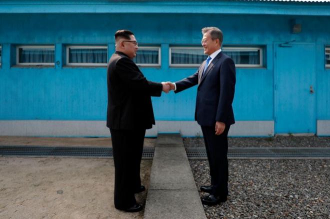 El líder de Corea del Norte, Kim Jong Un (L) estrecha la mano de su...