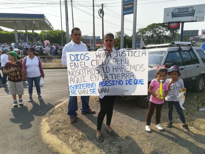 Una manifestante sujeta una pancarta en la que solicita al Gobierno de  Ortega que se vaya.