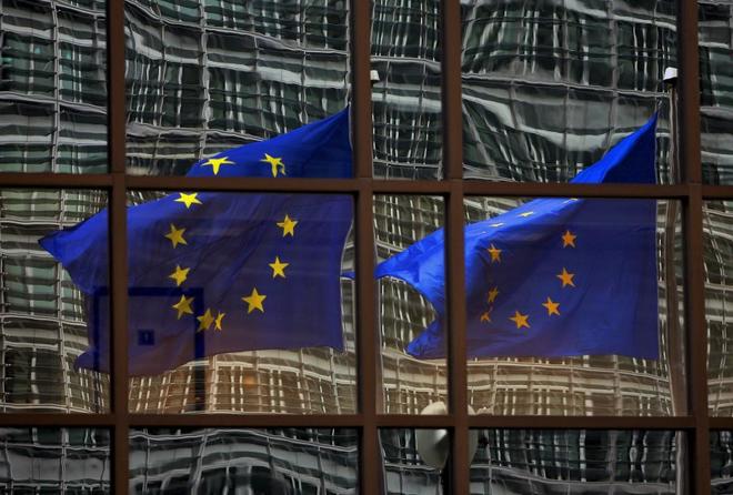 Dos banderas de la Unin Europea, reflejadas en el edificio del...