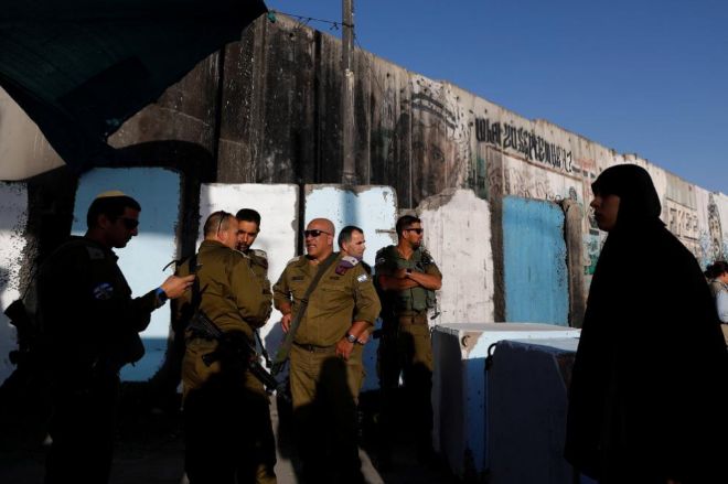 Soldados israeles vigilan un puesto de control cerca de la mezquita...