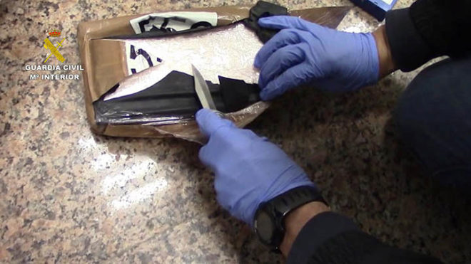 Un agente abre uno de los paquetes que contienen la droga.