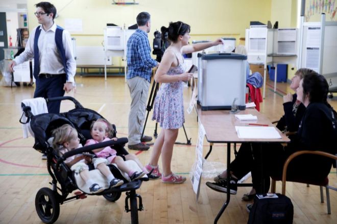 Un mujer acude con sus hijos a las urnas en Dubln, la capital de la...