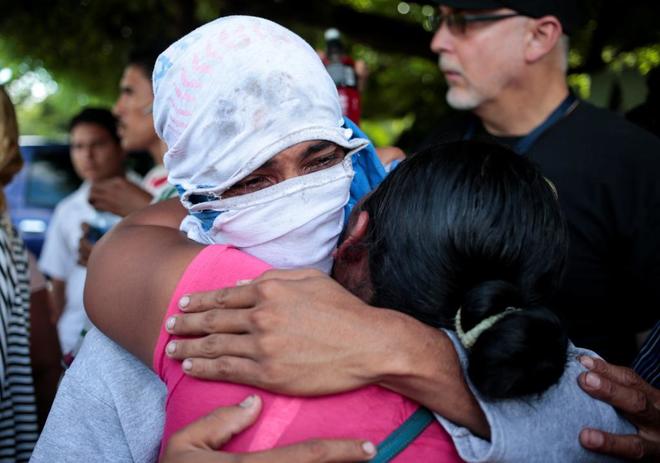 Una madre abraza a su hijo, arrestado por participar en una protesta...
