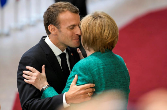 EPA5210. BRUSSELS (BELGIUM), 26/06/2018.- El presidente galo, Emmanuel Macron (i), saluda a la canciller alemana, Angela Merkel, a su llegada a la cumbre de los jefes de Estado y Gobierno de la Unión Europea (UE) que se celebra en Bruselas (Bélgica) hoy, 28 de junio de 2018. Los líderes de la UE tienen previsto apoyar hoy la creación de "plataformas de desembarco" de inmigrantes en el extranjero y dar luz verde a los pactos bilaterales entre Estados miembros que eviten que los inmigrantes se muevan por el bloque para solicitar asilo donde más les interesa. EFE/ Nicolas Lambert