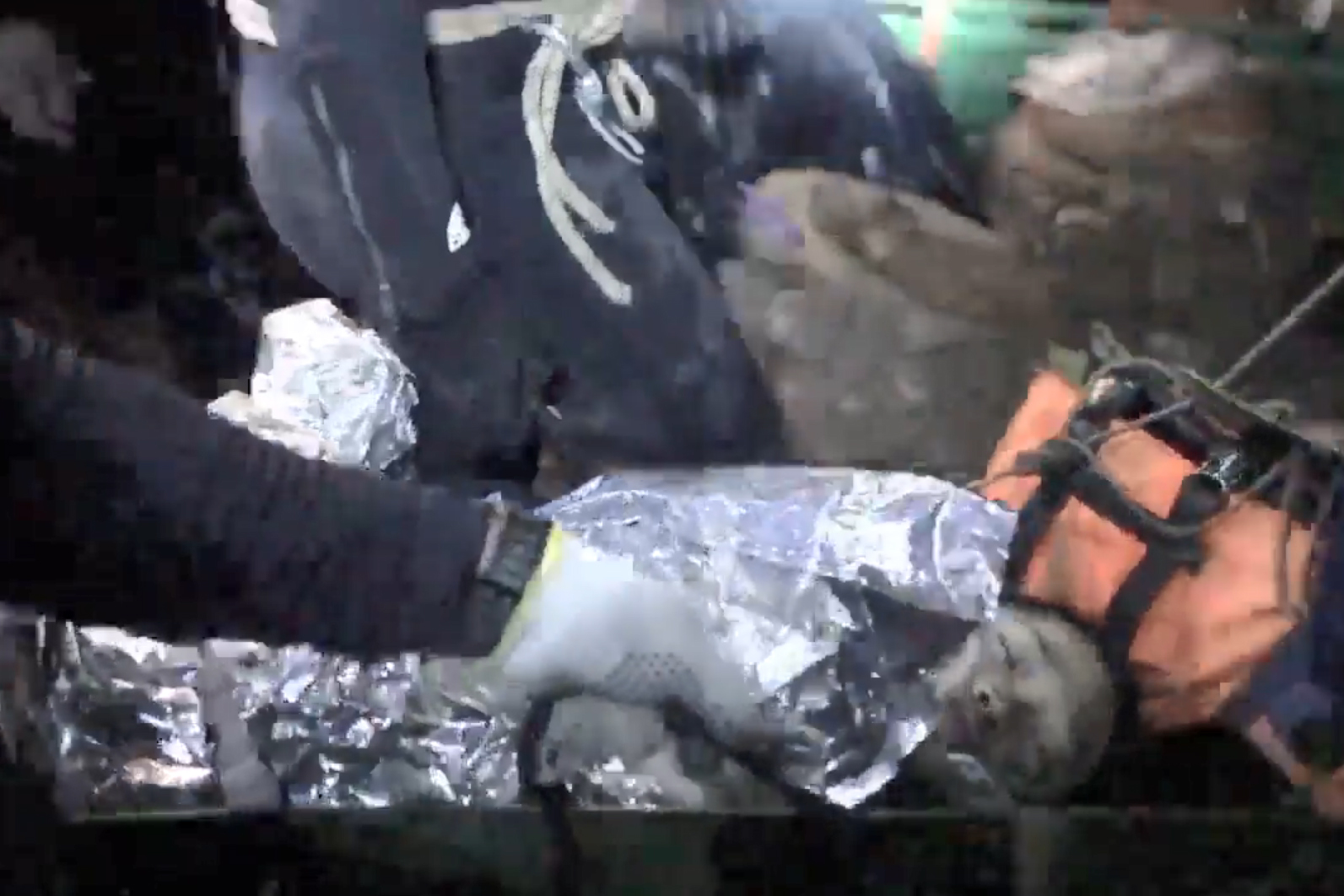 Imagen proporcionada por los rescatistas, en la que aparece uno de los menores dormido en una camilla.