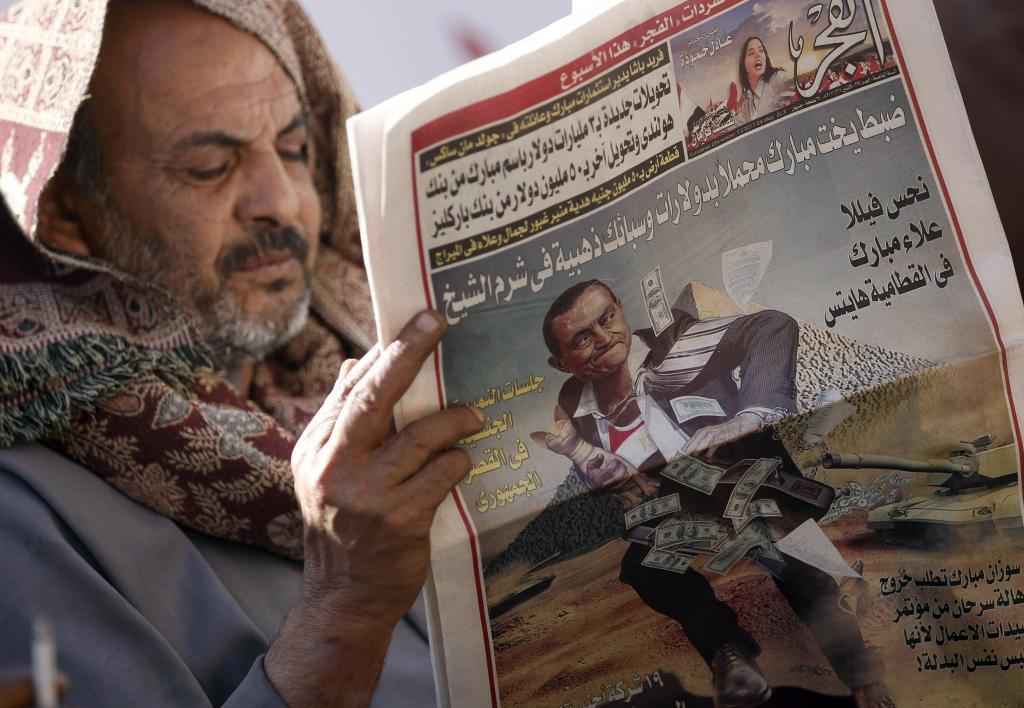 Un hombre lee un peridico en El Cairo.