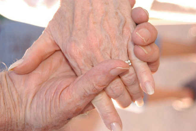 Una pareja de abuelos enamorados se coge la mano.
