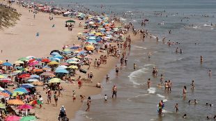 Miles de baistas disfrutan del mar en la playa de Cullera, en...