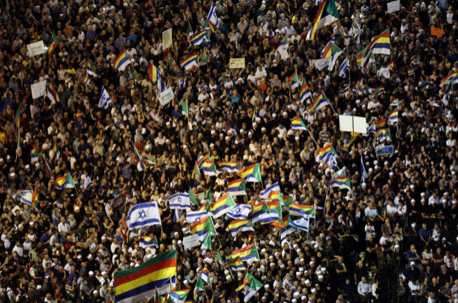 Israelis from the Druze minority, together with others, hold Israeli national flags and Druze's flags as they take part in a rally to protest against Jewish nation-state law in Rabin square in Tel Aviv, Israel, August 4, 2018 REUTERS/Corinna Kern