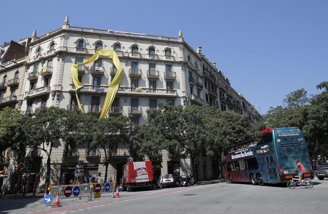 Un lazo amarillo cubre parte de una fachada en la calle Sicilia de...