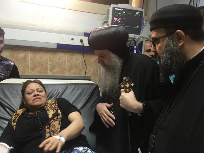 Sacerdotes coptos de Egipto hablan con una mujer herida en el atentado...