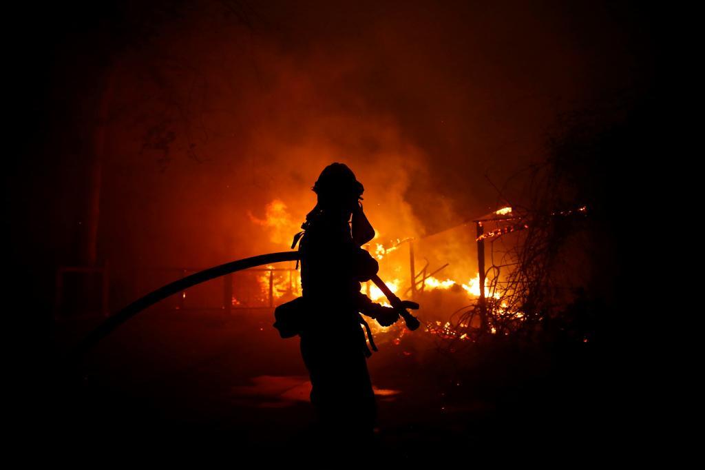 Un bombero lucha contra el incendio de Woolsey en Malib, California,...