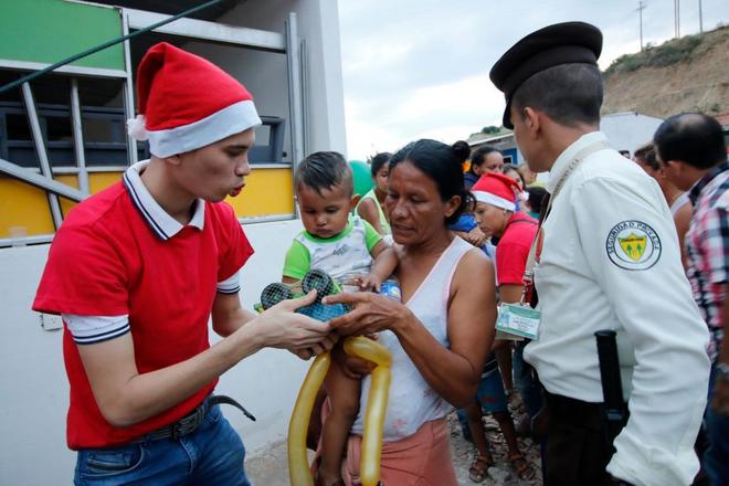 Un trabajador del Gobierno colombiano entrega un regalo a un migrante venezolano en Ccuta,  Colombia.