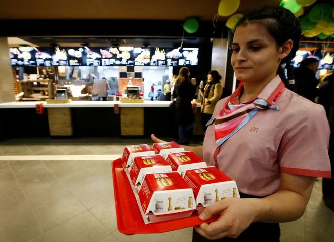 Una empleada de McDonald&apos;s con varios Big Macs, en imagen de archivo.