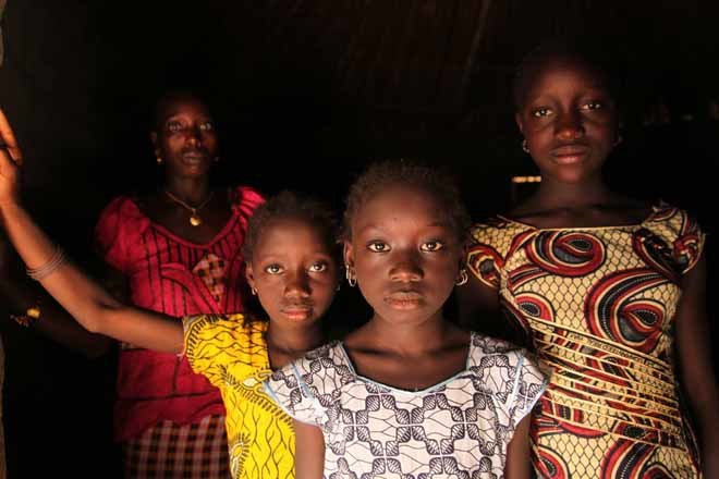 Una mujer y sus hijas posan en las puertas de su casa en Guinea Bisau.