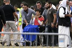 Zaed Mustafa  (C, en silla de ruedas), herido por un pistolero australiano supremacista, asiste al funeral de su padre asesinado, Khaled Mustafa, y de su hermano Hamza Mustafa en el cementerio de Memorial Park en Christchurch.