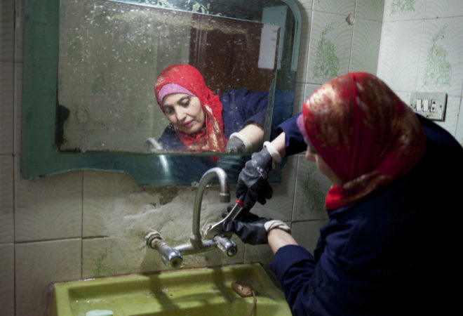 Maysar Abu Syam reparando un lavabo en una casa de Zarqa (Jordania).