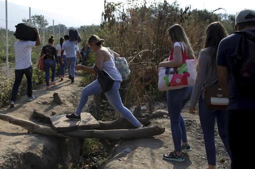 People walk along a pathway near the Colombian-Venezuelan border in...