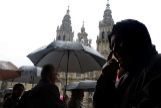 Varios peregrinos, bajo la lluvia, en Santiago de Compostela durante Semana Santa.