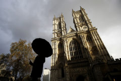 Una persona con paraguas camina frente a la Abada de Westminster, en Londres.