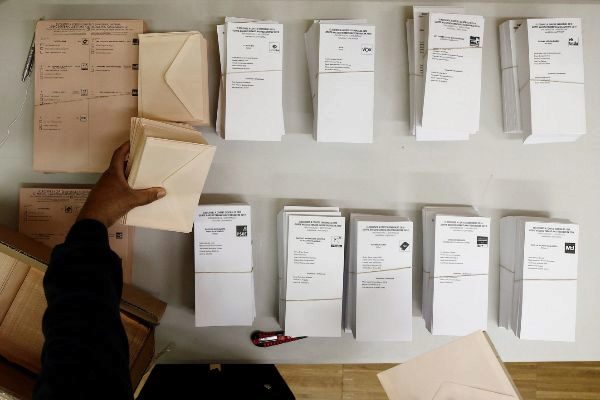 Un hombre ordena papeletas electorales en un colegio de Pamplona.