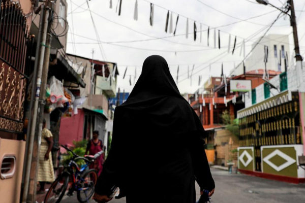 A <HIT>Muslim</HIT> woman wearing a hijab walks through a street near...